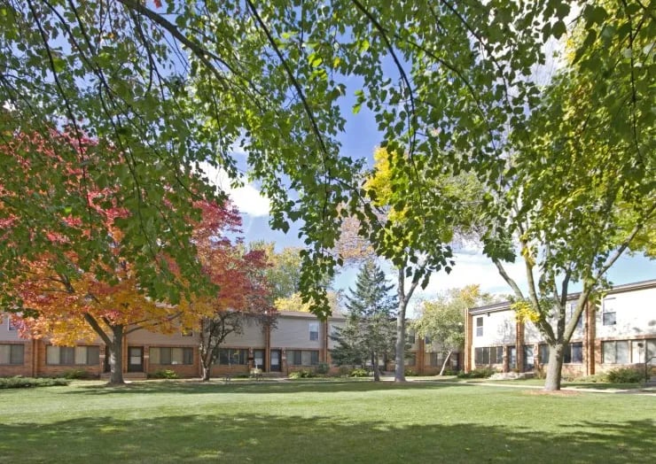 Glendale Townhomes courtyard in fall, with red maples and a wide lawn between the brick townhome rows