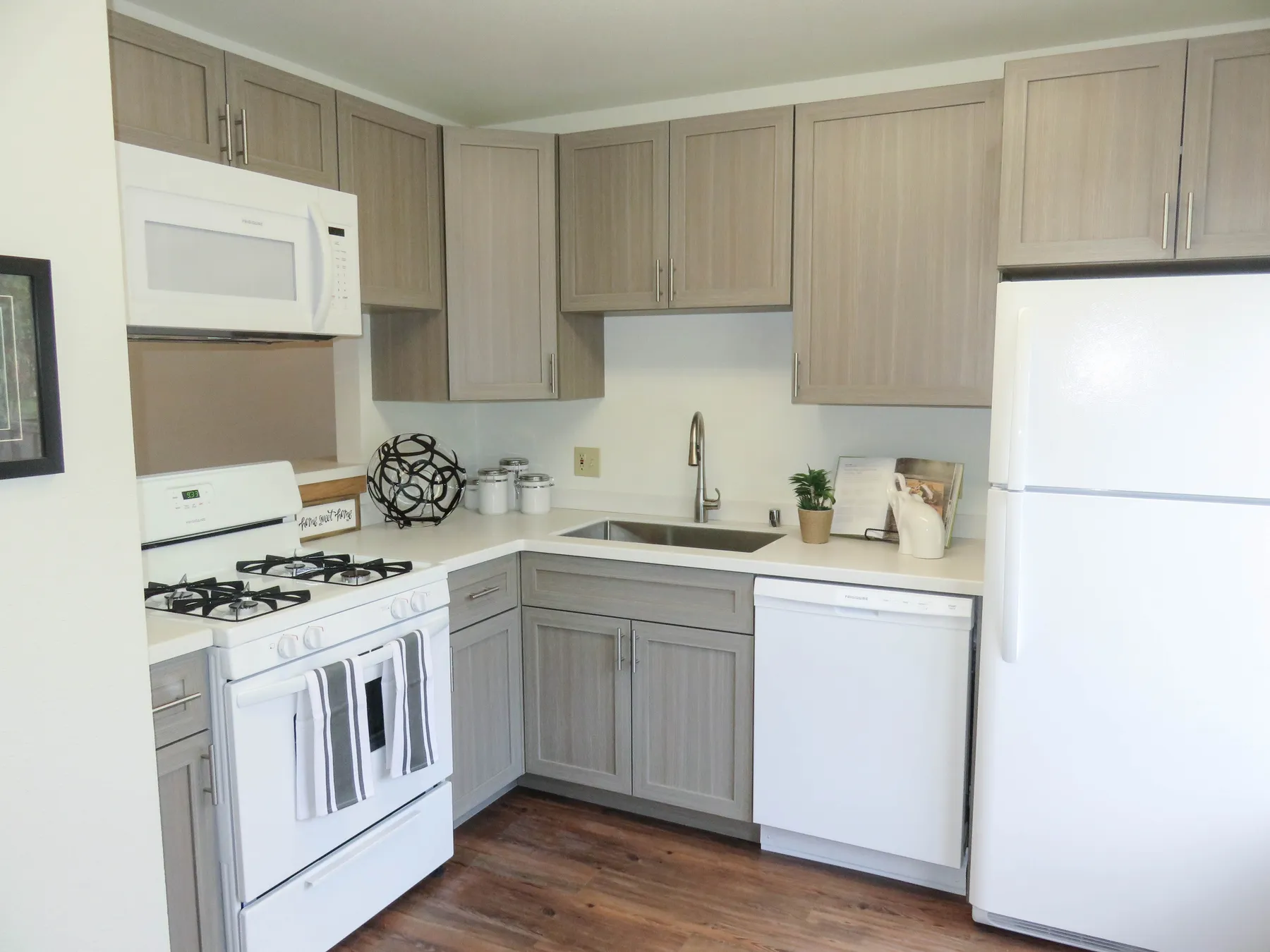 Renovated townhome kitchen with gray shaker cabinets and a gas range