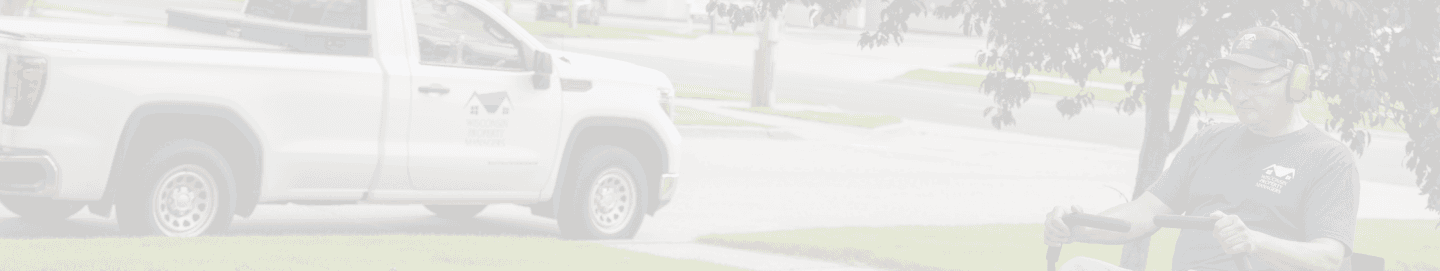 Maintenance worker of WPM riding a lawn mower, cutting the grass of a property